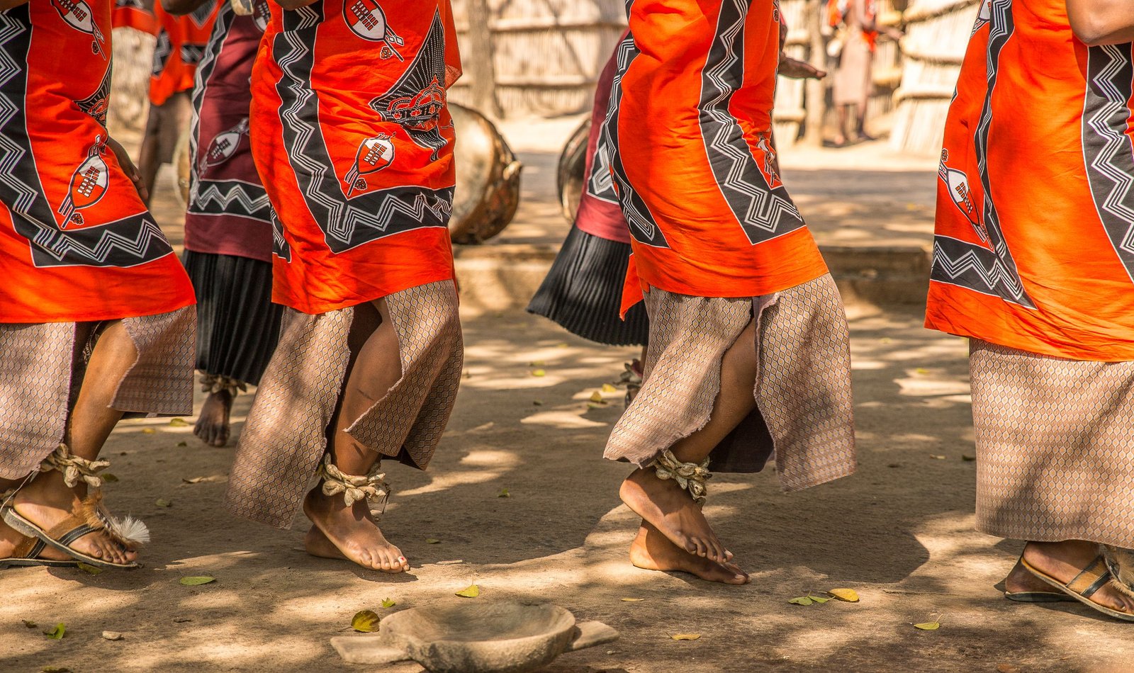 Traditional dancers in vibrant costumes performing a cultural ceremony outdoors.