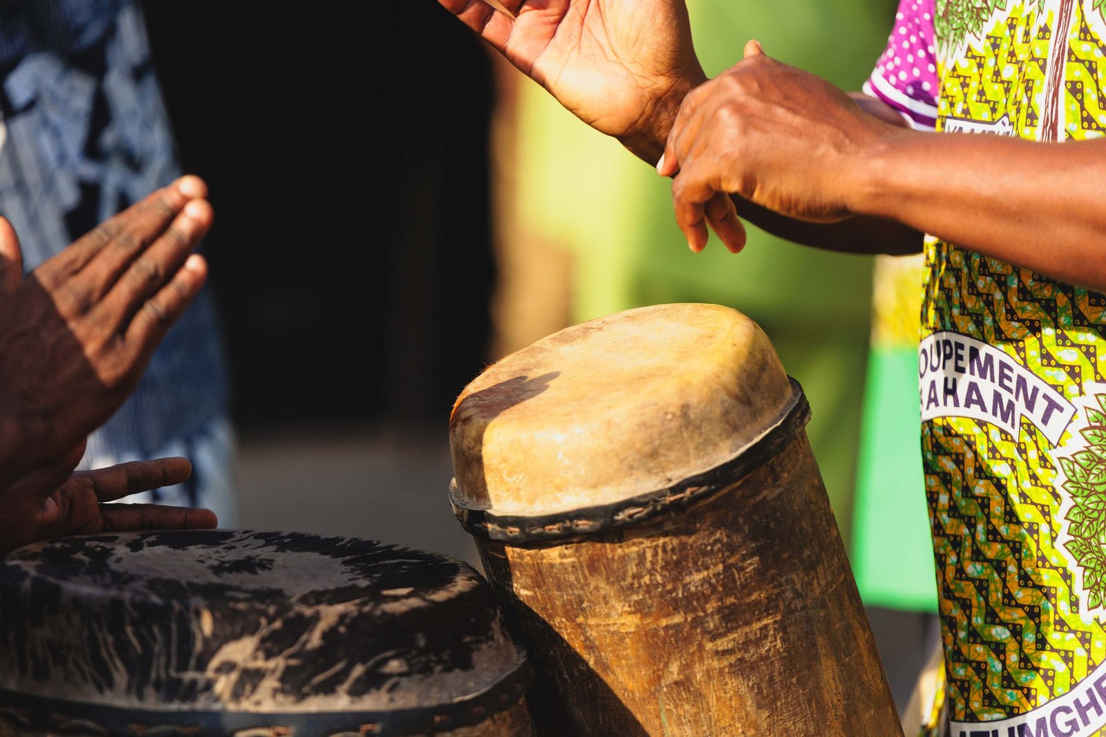 Vibrant image of hands playing traditional drums, emphasizing cultural rhythm and music.